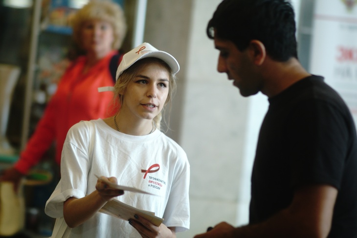 Волонтер раздает листовки о ВИЧ