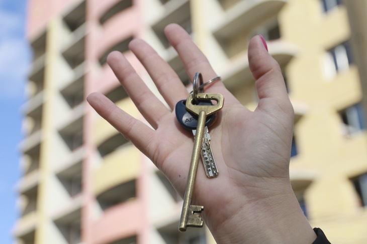 Ключ от квартиры на фоне новостройки