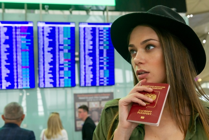 девушка с паспортом в аэропорту