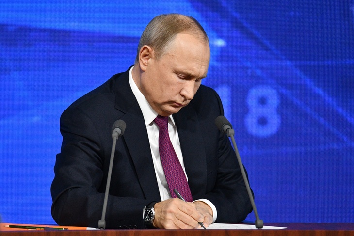 Владимир Путин подписывает документы