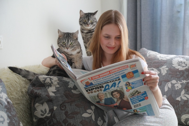 Девушка читает газету "Комсомольская правда" дома